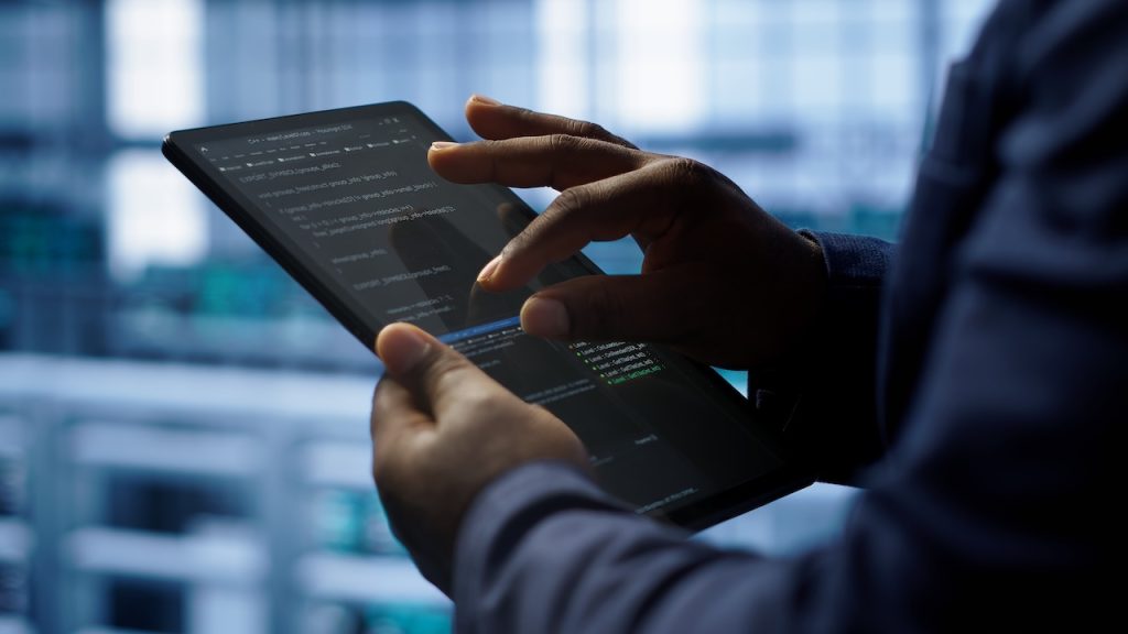 a man is holding a tablet in an office setting