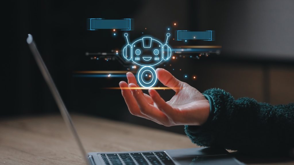 hand holding a bot hologram over a laptop